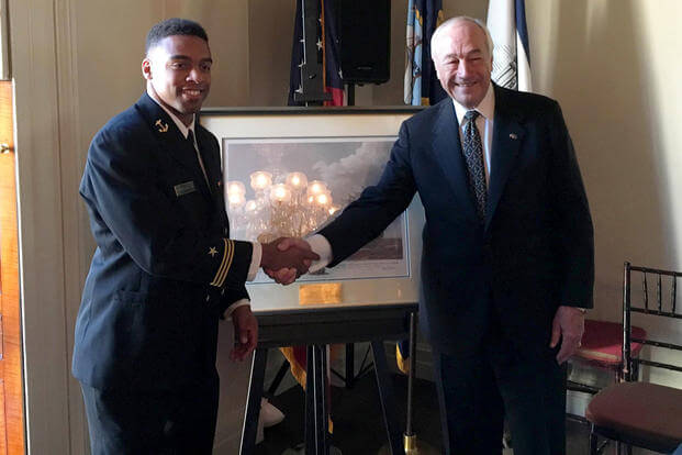 Naval Academy Midshipman 1st Class Keenan Reynolds shakes hands with former Secretary of the Navy John Dalton during an award presentation at the Historic Decatur House. (U.S. Navy Photo by Cmdr. John Schofield/Released)