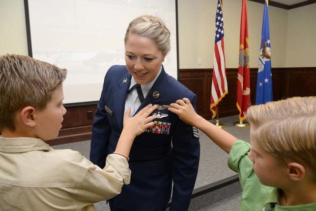 Tech. Sgt. Courtney has her remotely piloted aircraft wings pinned on by sons David and Riley during an RPA Training Course graduation Aug. 4, 2017, at Joint Base San Antonio-Randolph. (U.S. Air Force/Ave I. Young)