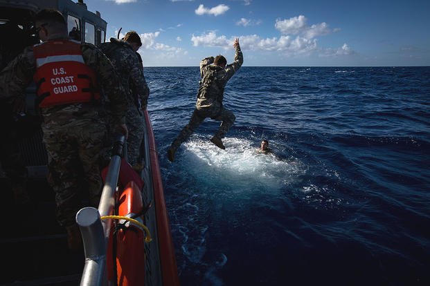 Pilots of 2-6 Cavalry Regiment, 25th Combat Aviation Brigade enter the ocean off the coast of Honolulu from a Coast Guard rescue boat Feb 17. (U.S. Army photo by Sgt. Daniel K. Johnson)