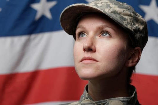 Female veteran in front of an American flag.