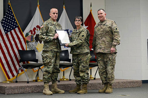 Command Sgt. Maj. Mark Bowman, the State Command Sergeant Major, Illinois National Guard presents a certificate of promotion to Sgt. Maj. Sharon Hultquist of Delavan, Illinois. (U.S. Army National Guard/SSgt Robert R. Adams)