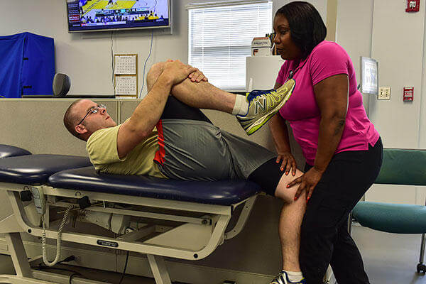 Virginia Lindsey, 1st Special Operations Medical Group physical therapy assistant, performs a quad muscle stretch on Tech. Sgt. James Kitchen at the physical therapy clinic on Hurlburt Field, Fla. (U.S. Air Force/Senior Airman Jeff Parkinson)