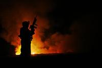 A Marine watches over a burn pit at Camp Fallujah, Iraq, May 25, 2007. (Samuel Corum/U.S. Marine Corps)