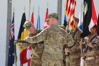 Maj. Gen. Walter Piatt, right, commander of Combined Joint Forces Land Component Command and his senior enlisted advisor, Command Sgt. Maj. Samuel Roark, left, rolls up the CJFLCC flag during a deactivation ceremony in Baghdad, Iraq, April 30, 2018. (U.S. Army/Sgt. Jonathan Pietrantoni)