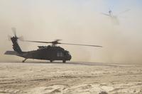 U.S. Army Soldiers turn away as two UH-60 Black Hawks fly overhead, Nov. 15, 2017 at Tactical Assembly Area Fuhaymi, Iraq. (U.S. Army/Spc. Avery Howard)