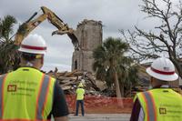 Construction workers look on as the Chapel 2 steeple is demolished at Tyndall Air Force Base, Fla., Feb. 15, 2019. (U.S. Air Force/Senior Airman Javier Alvarez)