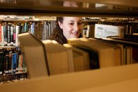 A woman shelves books.