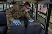 U.S. Air Force Staff Sgt. Colton Webber decontaminates a bus after transporting passengers from the aircraft at Joint Base Pearl Harbor-Hickam.