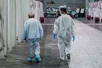 A soldier assigned to Javits New York Medical Station walks with a patient who is recovering from COVID-19.