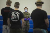 Lt. Cmdr. Jennifer Knapp briefs USS Roosevelt sailors on COVID-19 quarantine procedures.