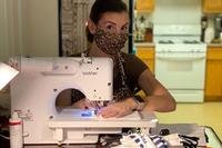 woman wearing a mask sewing