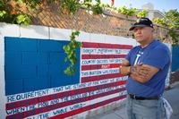Marine veteran Cesar Lopez poses by a mural on a wall outside his home in Las Vegas, Aug. 12, 2020. 
