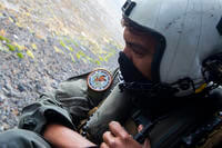 Naval Air Crewman (Helicopter) 2nd Class Joseph Rivera looks out of a U.S. Navy MH-60 Seahawk while conducting search and rescue operations following an AAV-P7/A1 assault amphibious vehicle mishap off the coast of Southern California.