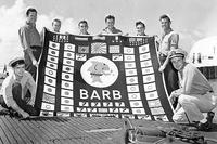 Members of the USS Barb's demolition squad pose with her battle flag at the conclusion of her 12th war patrol