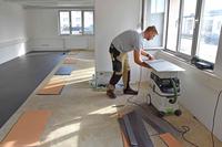 An employee installs flooring at the Wiesbaden, Germany, barracks