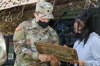 A recruiter shows a high school student how to call for fire.