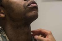 An airman receives an inspection during a shaving waiver course.