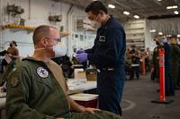 Capt. P. Scott Miller, left, commanding officer of Nimitz-class nuclear aircraft carrier USS Carl Vinson (CVN 70), receives the COVID-19 vaccine from Hospital Corpsman 3rd class Ang Li aboard the ship. (U.S. Navy/Mass Communication Specialist 2nd Class Christian M. Huntington)