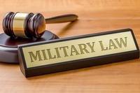 Image of gavel and placard reading military law