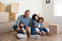 A family sits with boxes