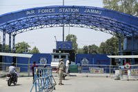 A police officer stands outside the Jammu air force station after two suspected blasts were reported in Jammu, India.