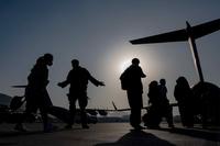 U.S. Air Force airmen guide evacuees aboard a U.S. Air Force C-17 Globemaster III