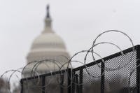 The U.S. Capitol is seen behind the razor fence