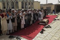 Residents pray during a funeral ceremony for victims of a suicide bombing.