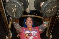 A sailor performs the bench press with dumbbells.