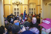 A U.S. Capitol Police officer is surrounded by rioters