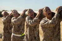 Marine recruits carry a log.