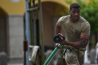 An airman drags a fire hose during Police Week at Aviano Air Base, Italy.