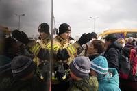 People fleeing from Ukraine queue to board on a bus at the border crossing in Medyka, Poland.