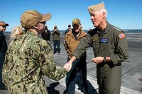 Vice Adm Kenneth Whitesell presents a coin.