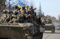Ukrainian soldiers ride a tank through the town of Trostsyanets.