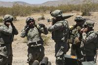 U.S. Army soldiers plug their ears while conducting a mortar fire mission.