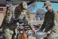 Airmen prepare a turkey for a Thanksgiving meal.
