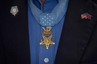 A Medal of Honor hangs on recipients chest.