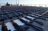 Thousands of AK-47 assault rifles on the flight deck of guided-missile destroyer USS The Sullivans