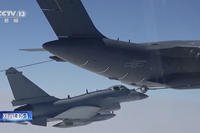 A Chinese fighter jet performs an mid-air refueling maneuver.