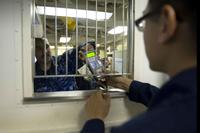 U.S. Navy sailor receives assistance with a cash transaction.