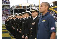 Petty Officer 1st Class David Goggins, special warfare operator, stands at attention with members of the U.S. Naval Academy's triathlon team