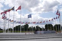 Men do construction work around the flags at NATO headquarters.