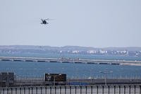 A Russian military helicopter flies over damaged parts of Crimean Bridge 
