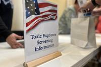 A sign on a table announces states &quot;Toxic Exposure Screening Information&quot;