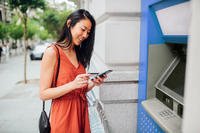 Woman on phone next to ATM