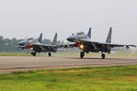 Two Chinese Su-30 fighter jets take off from an unspecified location.