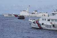 Philippine supply boat, center, maneuvers around Chinese coast guard ships as they tried to block its way