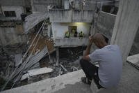 Palestinians inspect a damaged building following an Israeli army raid.