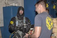 Navy Diver 2nd Class Shane Cone, assigned to Mobile Diving Salvage Unit 1, prepares to deploy a boom designed to prevent contaminants from potentially entering the pump system at the Red Hill well as part of well recovery efforts.